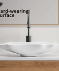 HAOCHRYSYPH Ceramic Shell Vessel Sink Bowl, Milk White, 24.41x13x4.73 in. view with modern faucet on wood counter.