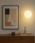 Minimalist Globe Wall Sconce, 1-Light White E27 Round Wall Light Fixture illuminating a wall above a wooden side table.