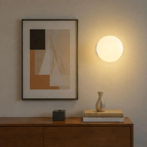 Minimalist Globe Wall Sconce, 1-Light White E27 Round Wall Light Fixture illuminating a wall above a wooden side table.