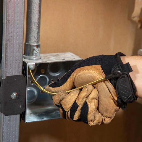 Person using Top Shelf 13 Inch Flexible Fish Tape Leader For 1/8 Inch Steel Tapes in electrical box with gloves.