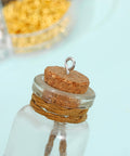 Close-up of a corked glass bottle with an eye screw inserted, showcasing the 7 Color 450 Piece Eye Screw Pins Set Eight By Four Millimeter Tiny Eyelets For Jewelry Making Bead Charms And DIY Crafts Handy Mini Eye Hook Screws For Arts Projects Ideal For Bead Charms Jewelry Making Mini Pendants And Craft Projects At Home Or Studio.