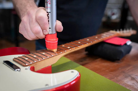 Using fretboard conditioner from Complete Guitar Care Kit And Clean Polish Set With Fretboard Conditioner on guitar neck.