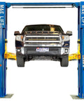 ME-LM110S blue two-post car lift with yellow arms lifting a pickup truck (front view).