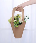 Hand holding 50 Pack Kraft Paper Flower Gift Bags Brown Hanging Bouquet Wrapping Bags For Home Decoration Durable 7.5 By 35 Cm 2.9 By 13.8 In