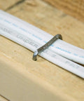 Pro-Grade Metal Staples 9 By 16 Inch, 5000-Count Bucket, recessed head securing cable to wood.