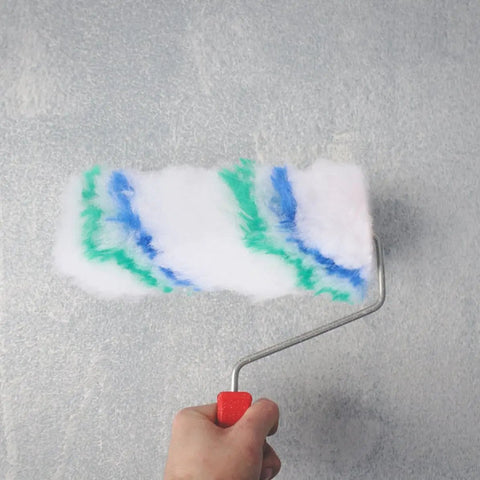 Mega Pack Of Twenty Soft Polyester Wall Paint Roller Brushes Delivers A Hella Smooth As Butter Finish Perfect For Painting Interior Walls Ceilings Canvas And Waterproof Coatings. Hand holding roller brush applying paint on wall.