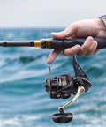 Close-up of All Around Spinning Reel For Freshwater And Saltwater Fishing, featuring a strong metal spool and tough handle in use
