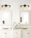 Three Light Black And Gold Bathroom Vanity Light Fixture With Metal Base And Clear Glass Globe Shades over two mirrors