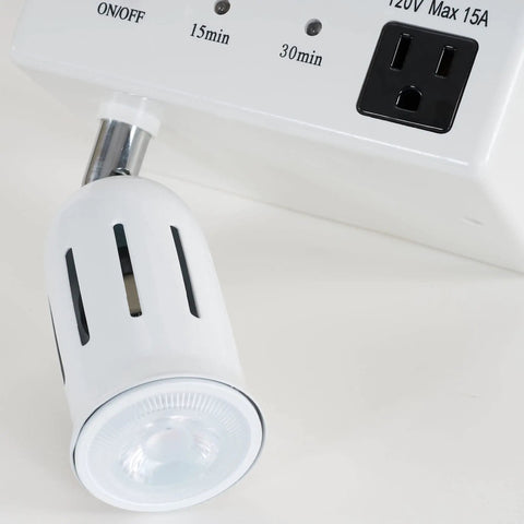 Close-up of Cabinet Light And Power Kit With 3 Prong Outlet And LED Spotlight Auto Off Timer White, showing outlet and spotlight.