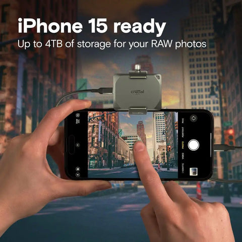 Person using iPhone 15 with external 4TB storage device for RAW photos in urban setting.