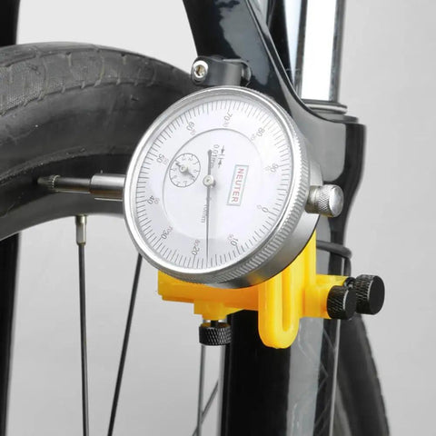 Close-up of Bike Wheel Truing Stand With Percentage Gauge For 26 Inch To 29 Inch Wheels Portable Home Repair Stand with yellow base.