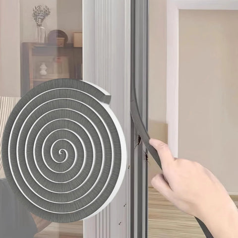 Side view of gray self-adhesive weather-stripping being peeled from a circular roll to seal a door frame