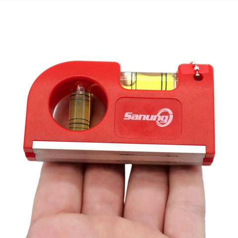 Close-up of red Two Piece Mini Magnetic Pocket Spirit Level with keychain on hand, showing magnetic base and two glass vials for leveling.