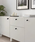 Matte Black Cabinet Knobs Four Pack with Wide Backplates on white dresser in modern living room