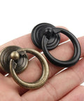 Hand holding Zinc Alloy Round Cabinet Pulls And Jewelry Box Drawer Knobs European Style Retro Door Handles For Dresser And Cupboard