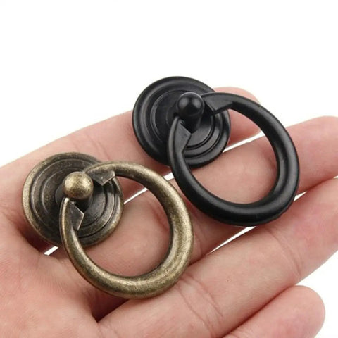 Hand holding Zinc Alloy Round Cabinet Pulls And Jewelry Box Drawer Knobs European Style Retro Door Handles For Dresser And Cupboard