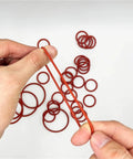 Silicone O Ring Set With CS Size Assortment 1 To 1.5 To 2.0 To 2.4 To 3.1mm Sealing Washers Oil Resistant And High Heat Tolerant Versatile Gasket Kit For Plumbing Automotive Machinery Marine And DIY Projects, red silicone O-rings held by hand