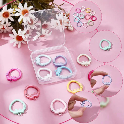 14 Color Spring Gate Ring Set For Keychains And Craft Projects With Strawberry Trigger Snap Buckles on display with daisies