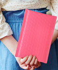 Person holding a 50 Pack Pink Bubble Mailers 16.5x22+4 Inch Self Seal Padded Envelopes for Small Business Shipping.