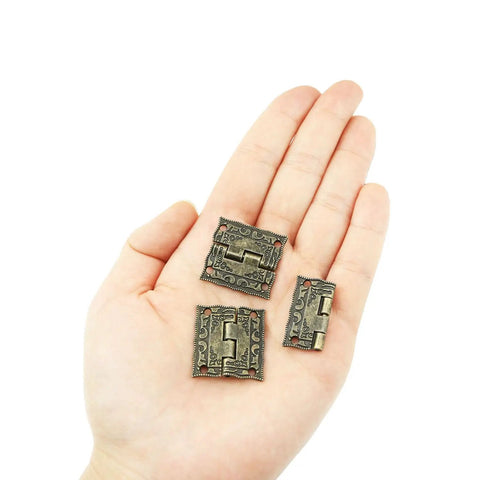 20 Piece Mini Patterned Bronze Hinges With Mounting Screws For Small Wooden Boxes External Flanged Hinge Set held in hand