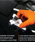 Person using Tough As Nails Eight Mil Orange Nitrile Work Gloves With Raised Diamond Texture for cleaning on a black surface.