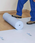 Person laying Temporary Floor Protection Roll 36 Inch By 100 Foot Anti Slip Surface Easy To Apply Paint Proof Reusable Durable Material
