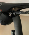 Close-up of Titanium Seatpost Ear Clamp Kit For Oval Carbon Rails 7x9 Bolt CNC Machined Aluminum Clamp on black bike seat.