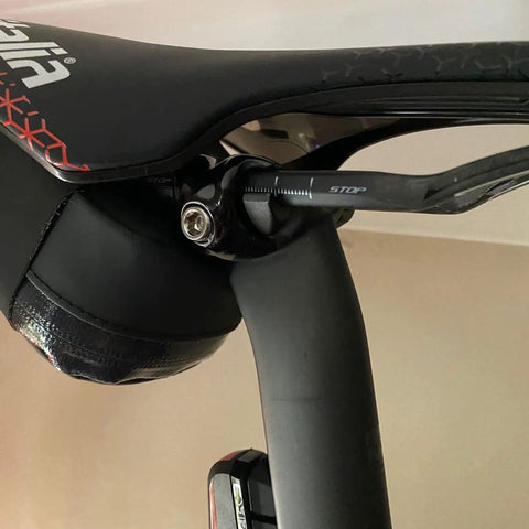 Close-up of Titanium Seatpost Ear Clamp Kit For Oval Carbon Rails 7x9 Bolt CNC Machined Aluminum Clamp on black bike seat.