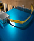 SIMpull Solid Indoor 12-2 With Ground NM-B Cable in use, yellow jacket through wiring hub on blue surface
