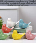 Super Clean White Bird Design Toilet Bolt Caps With Elegant Porcelain Screw Covers To Conceal Ugly Hardware And Level Up Your Bathroom Setup Effortlessly Inside This Solid Four Pack Collection displayed in various colors on stacked books.