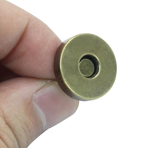 Close-up of a hand holding an 18mm magnetic snap from the 40 Sets Magnetic Snaps For Purses And Bags, 18mm Rustproof Fasteners Replacement Kit In 4 Colors.