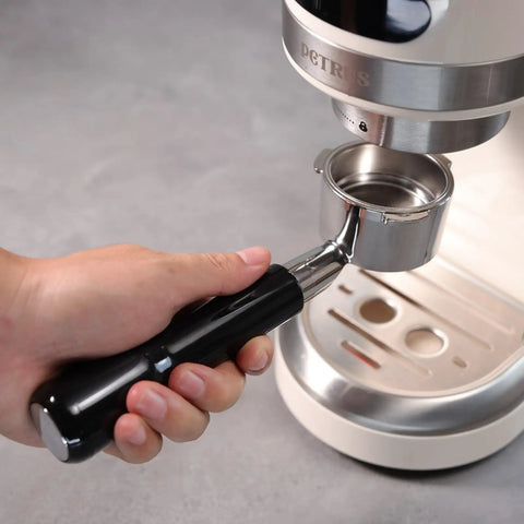 Person holding 51mm Bottomless Portafilter For Home Espresso Machines With 3 Ear Prongs, 4mm Thickness, Stainless Steel Filter Basket Included