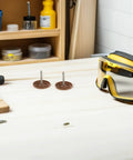 Top Tier Round Cap Roofing Nails With Insulation Washers Brown House Wrap Fasteners For Felt Foam Board And Weather Guard Sheathing 200 Piece Kit laid on a workbench with safety goggles.