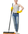 Person holding Heavy Duty Push Broom With 60 Inch Long Handle For Outdoor And Indoor Cleaning Versatile Garage Shop Deck Patio Concrete Tile Wood Stone Floor Broom With Ergonomic Grip And Extra Thick Bristles