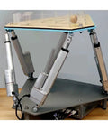 DOCYKE digital linear servo actuators in a front view on a four-arm DIY robot base supporting a wooden top with clear guard