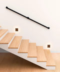 Kickass 7 Ft Indoor Stair Railing Featuring Matte Black Square Tube Handrail With Boss Level Non Slip Grip For Wall Mount Setup Totally Secure For Bathrooms Lofts And Kitchen Steps Rock Solid 500 Lb Rating, mounted along wooden stairs.
