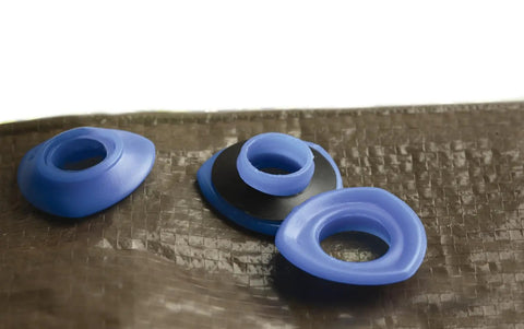 No Sweat Snap N Tap Grommets For Canvas And Tarp Jobs solid plastic fasteners on a nylon tarp surface.