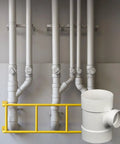 PVC DWV Sanitary Reducer Tee 4 By 4 By 2 Inch for drain waste and vent white plumbing fitting next to a piping system
