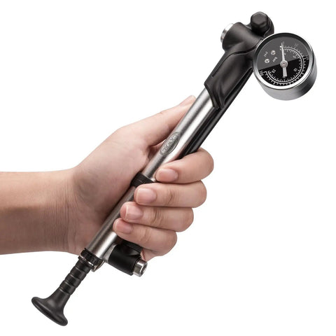 Person holding High Pressure Mountain Bike Shock Pump With Gauge For 300 PSI Front Fork And Rear Suspension No Loss Air Pump Easy Dial Tuning