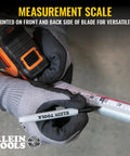 Gloved hands holding 9235 Heavy Duty Magnetic Tape Measure With 16 Foot Reach, measuring on metal surface