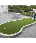 Man practicing on Pro Grade Indoor Outdoor Golf Putting Green Mat With Dense Artificial Grass Turf 5 Ft By 10 Ft For Home Practice Baseball Football Gym Sports Soft Feel High Density Synthetic Lawn