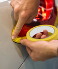 Applying Premium Automotive Painters Paper Tape For Car Detailing And Auto Body Work around vehicle trim for a paint job.