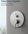 GRANDJOY 10" Wall Mount Shower System with Handheld Spray, Brushed Nickel control panel with 2 function knobs on grey wall.