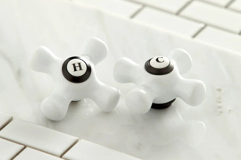 Close-up of porcelain cross handles for Heritage Widespread Lavatory Faucet With Porcelain Cross Handles In Oil Rubbed Bronze Solid Brass Construction Sleek 8 To 16 Inch Adjustable Center Deck Mount Three Hole Installation One Point Two GPM Flow IPS Connection Easy Install.