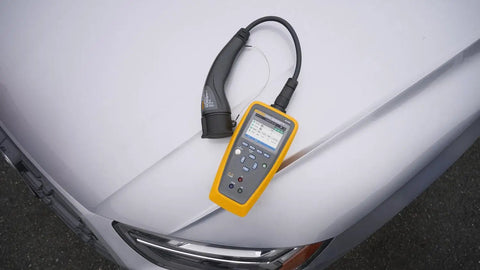Heavy Duty Electric Vehicle Charging Station Analyzer With Type 1 Plug For Knockout AC Diagnostic Testing on white car hood.