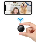 Ultra Compact WiFi Spy Camera With Remote Monitoring Night Vision being held, phone display showing nanny cam feed of child and dog.