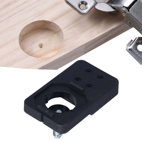 Black plastic hinge-boring jig for 35mm holes with mounting hardware on wood