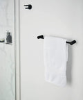 Dope Matte Black Double Swivel Robe Hook From Align Collection Modern Bathroom Accessory installed on wall with white towel