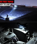 Rechargeable 100000 Lumen Spotlight With COB Flood Light on tripod illuminating rooftop and car engine at night.