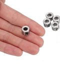 Hand holding a 5mm Bore Stainless Steel Shaft Collar with Set Screw from 12 Pack 5mm Bore Stainless Steel Shaft Collars With Set Screws 10mm Outside Diameter 7mm Wide Landing Gear Stopper Wheel Collar With Hex Wrench For Precise Positioning Spacing And Bearing Surface Applications with additional collars in background.